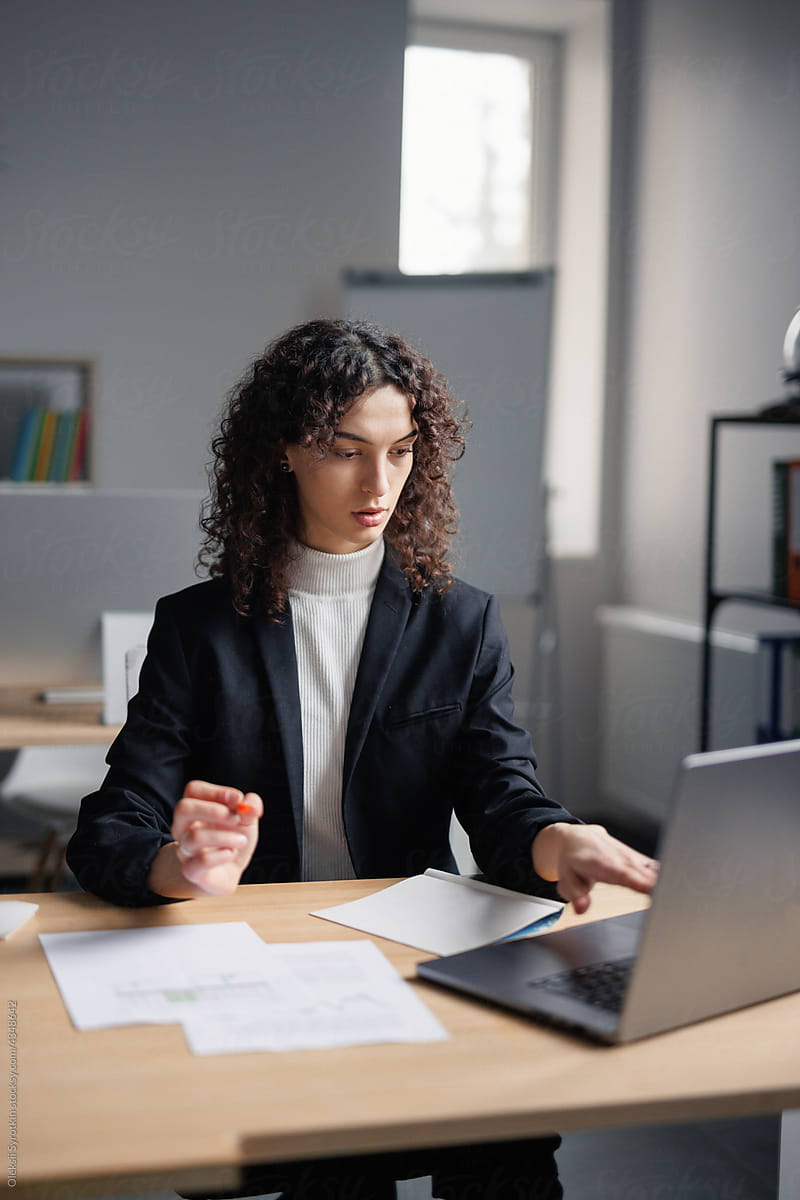 Focused female broker working on laptop in office