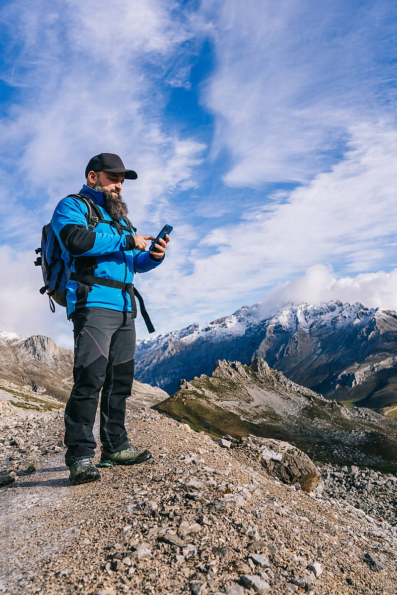 Male hiker browsing cellphone in mountains