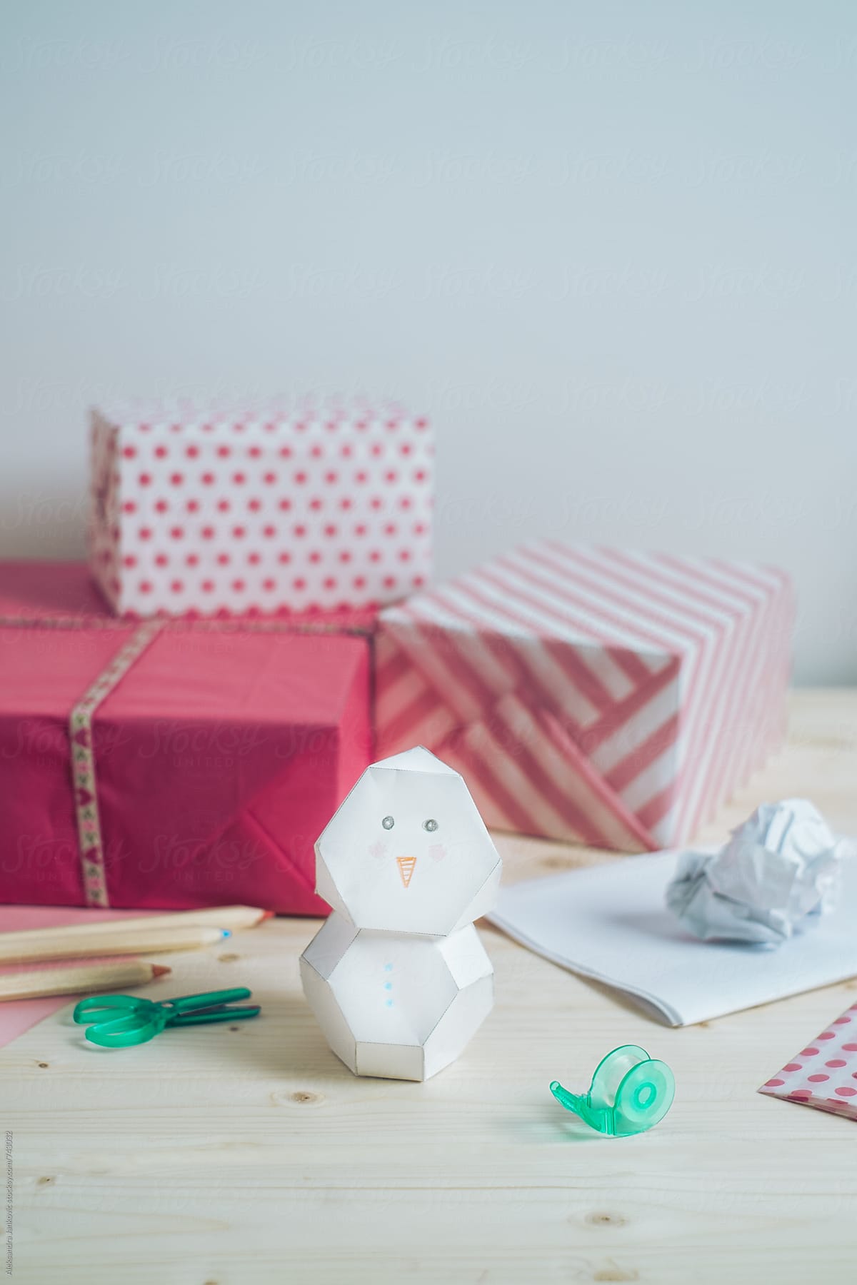 Paper Snowman On The Desk In Front Of Pink Christmas Presents