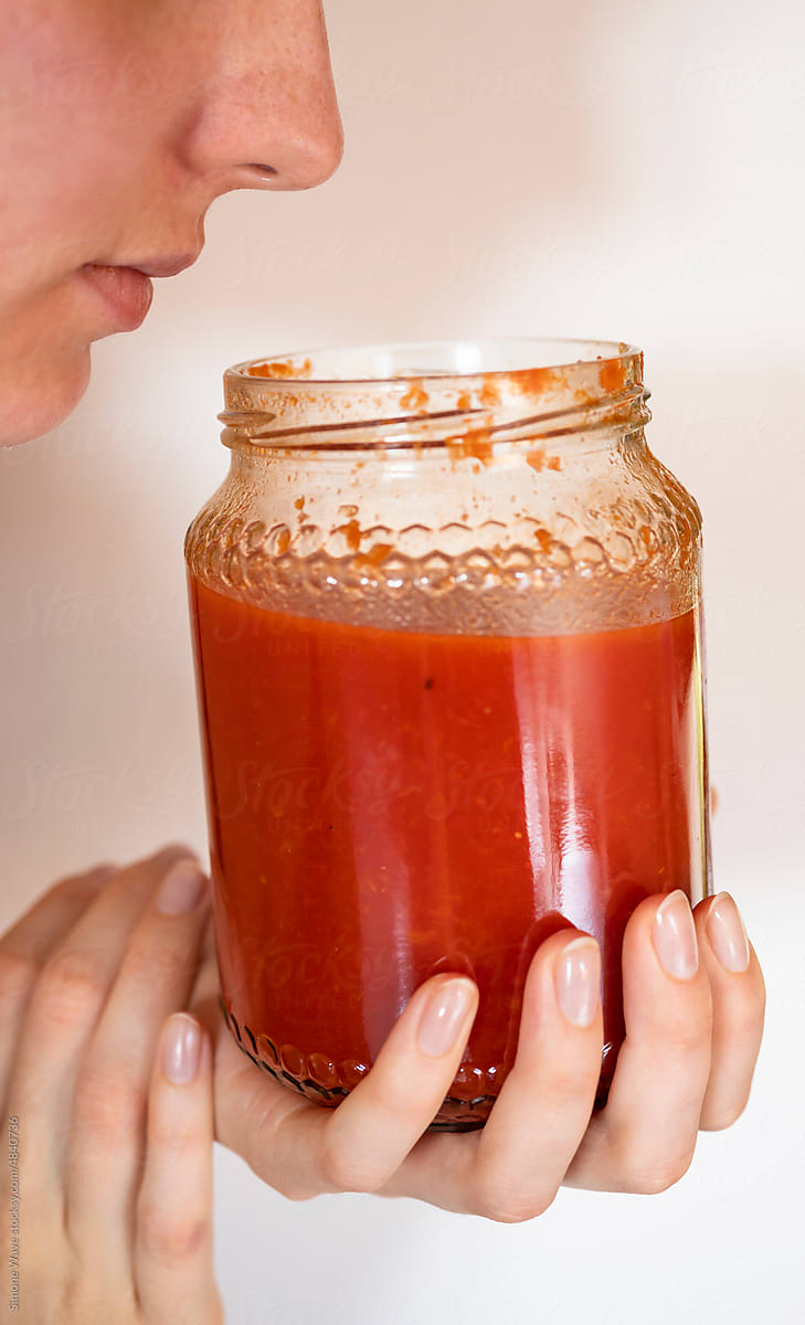 Woman smells and tasting homemade tomato passata sauce