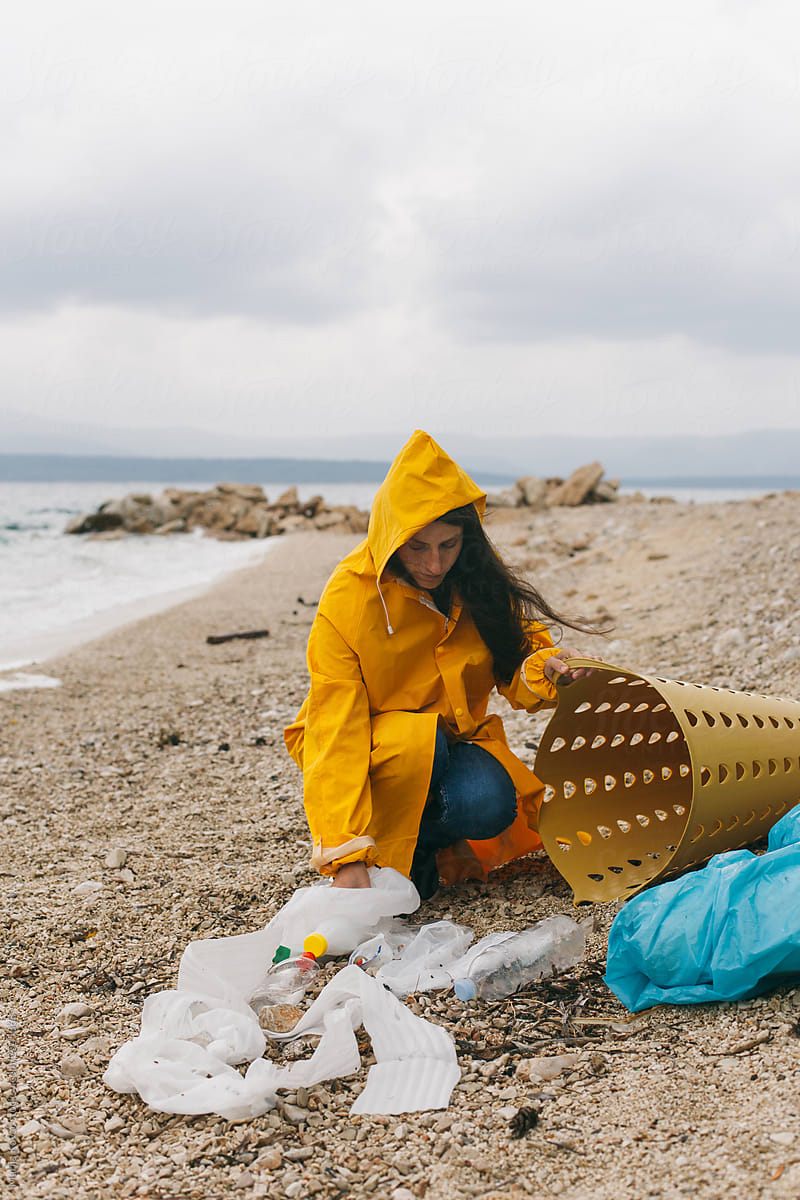 A woman cleaning a beach