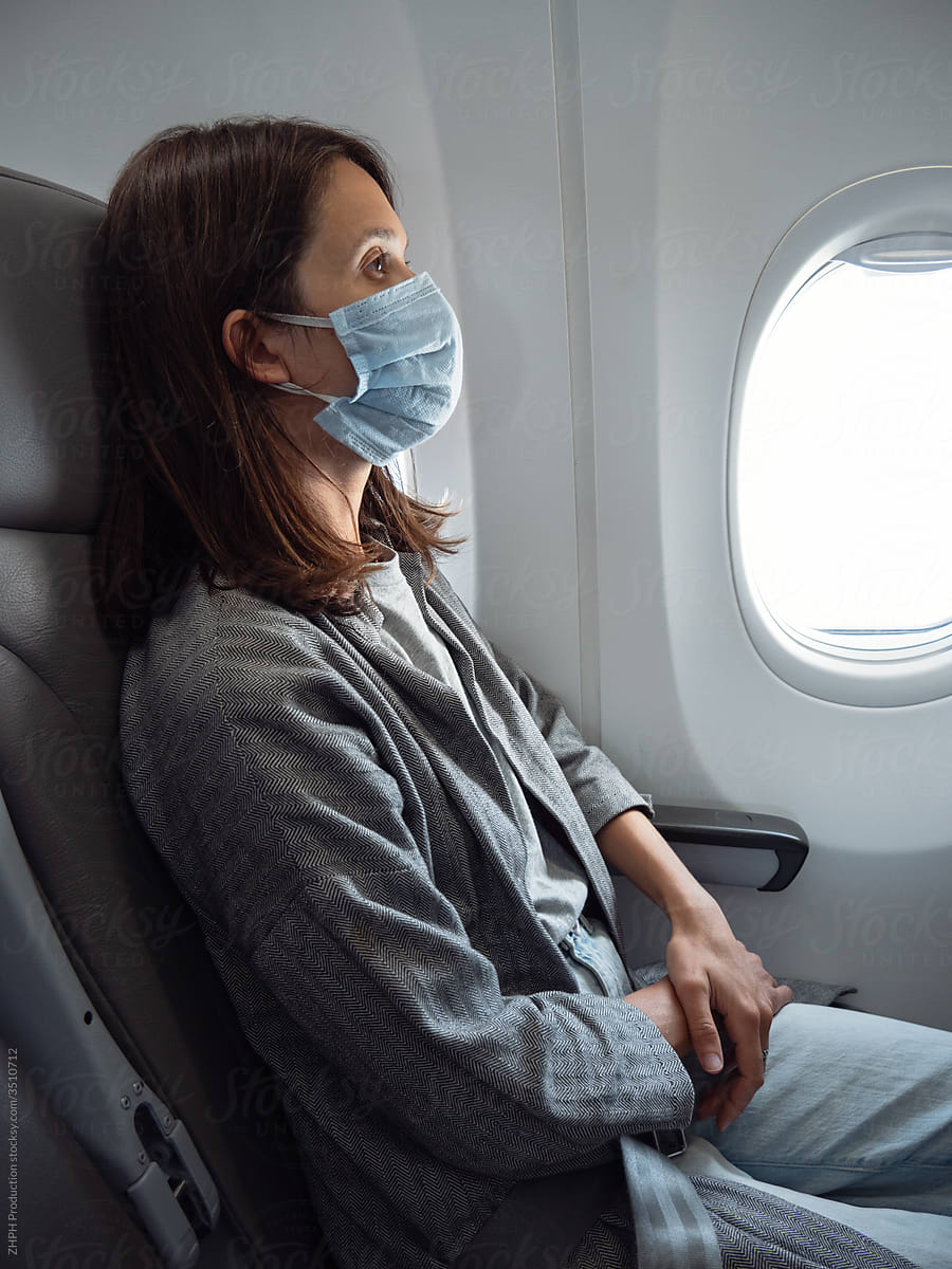 Woman wearing face mask in airplane