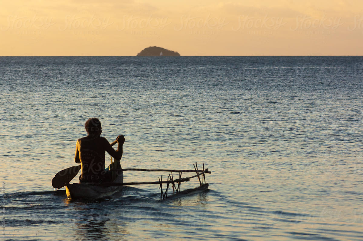 a man is paddling his outrigger canoe in the pacific ocean
