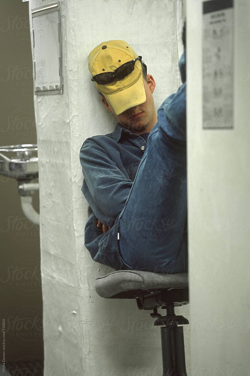 Young man sleeping in chair at work