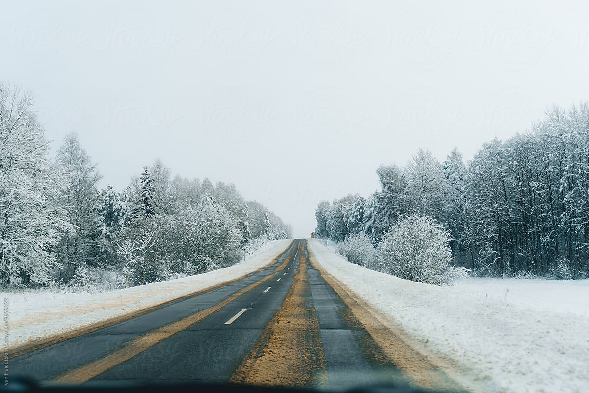 Winter Road Trip.Snowy forest drive on a slippery empty road.
