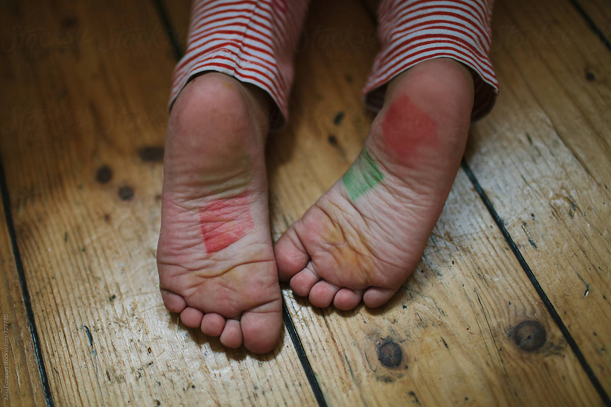 Child\'s feet covered in ink after a creative art session.