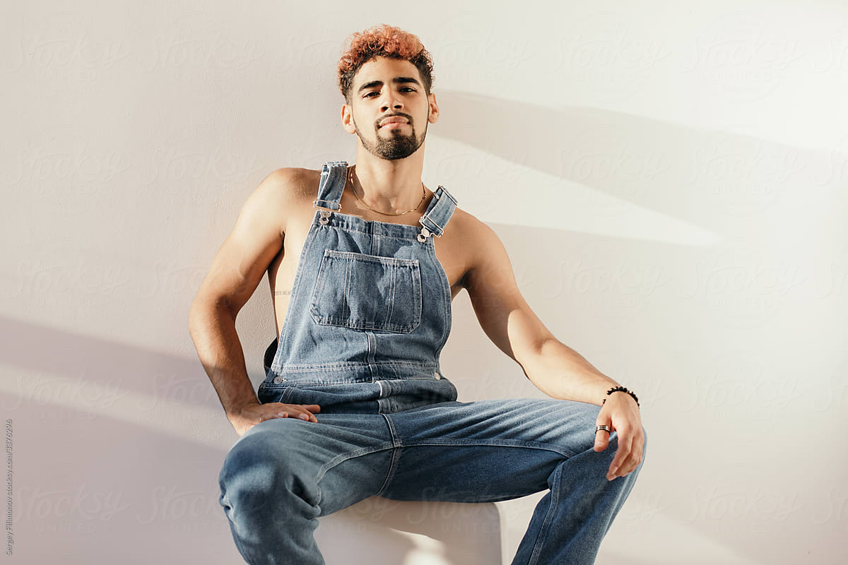 Stylish young ethnic man in denim jumpsuit