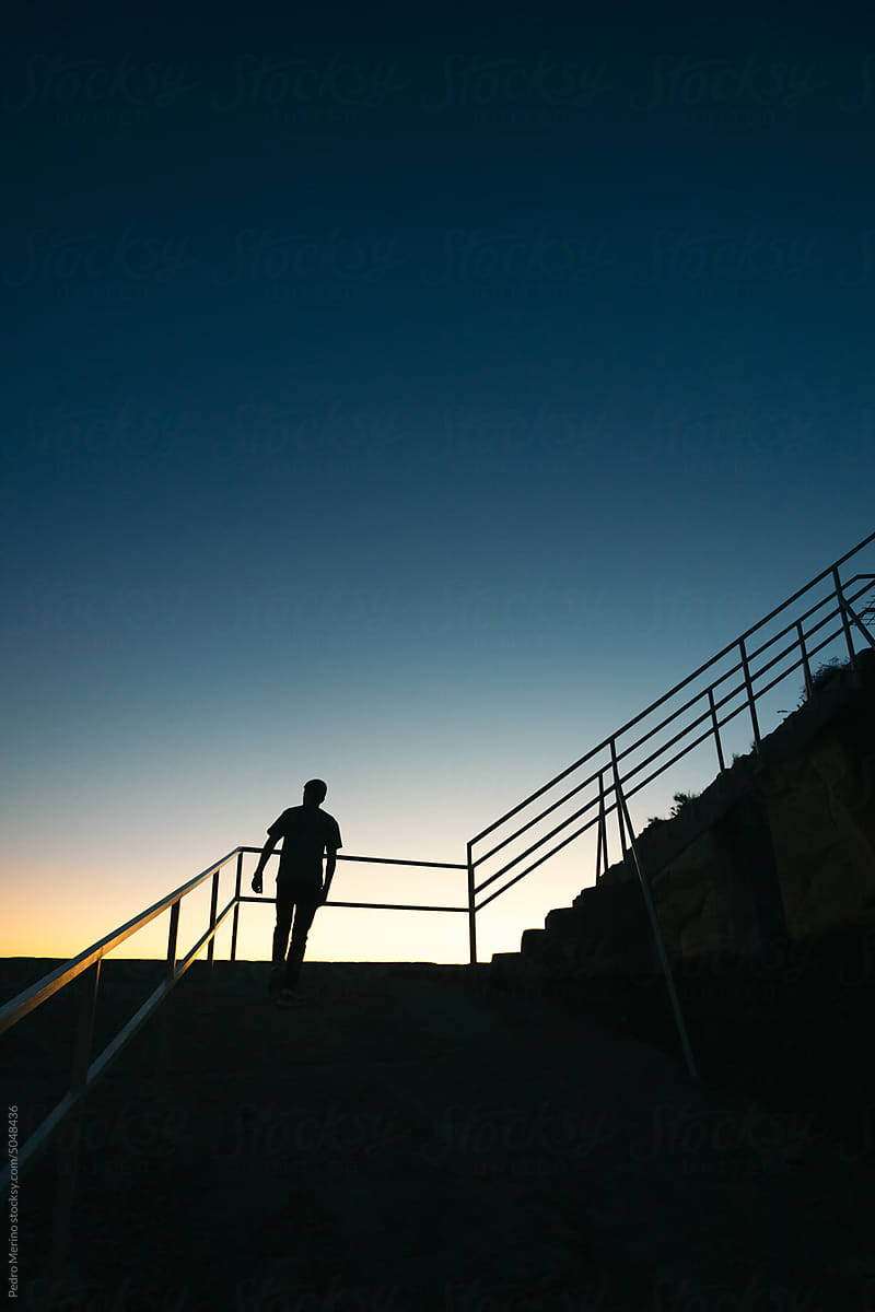Silhouette of a man going up stairs in the evening