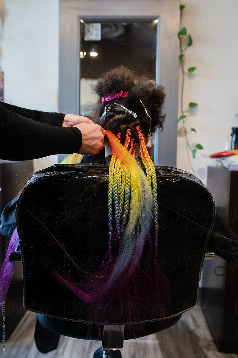 Girl gets rainbow box braids installed in salon