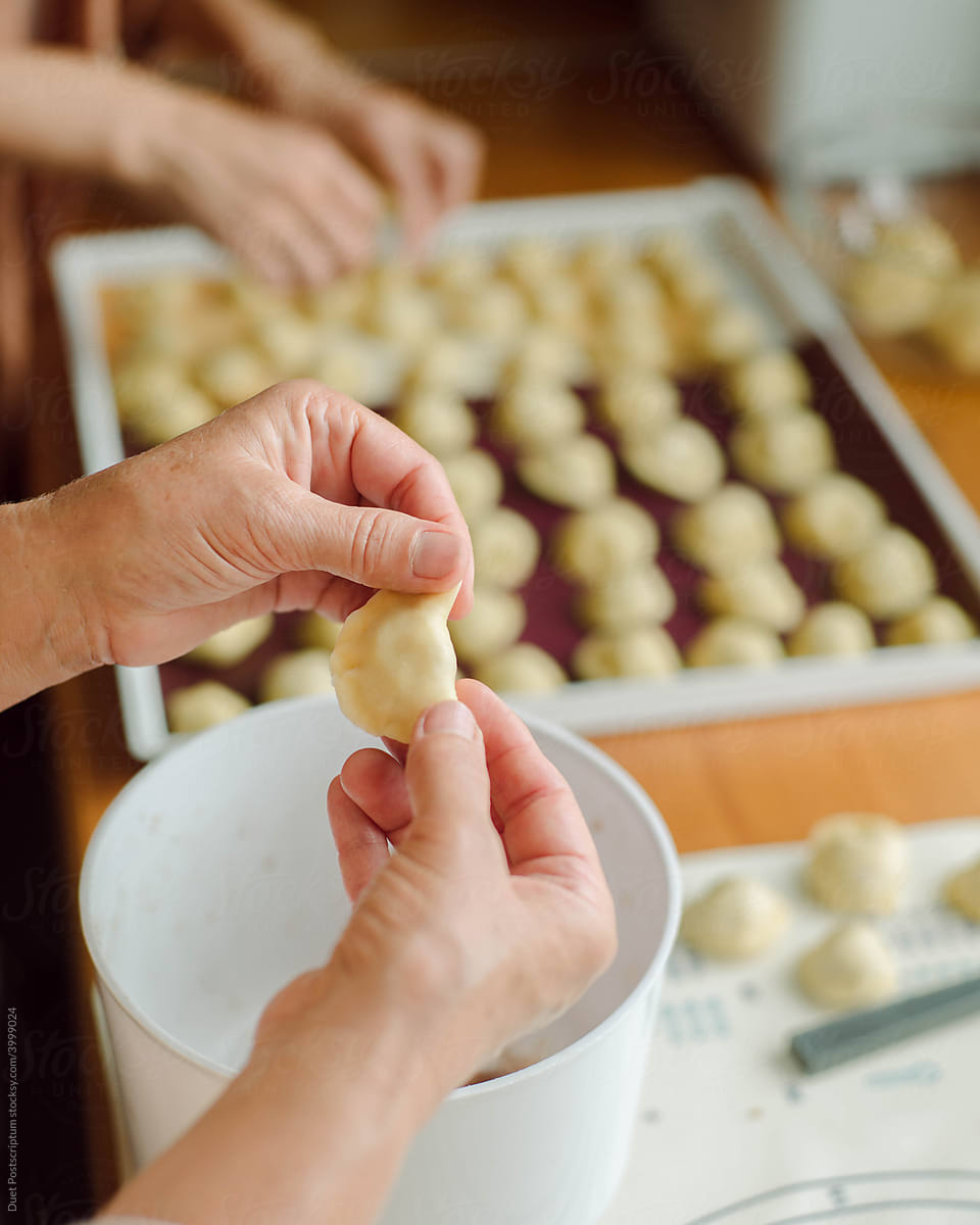 Woman’s hands cut with a knife for dumplings thin dough