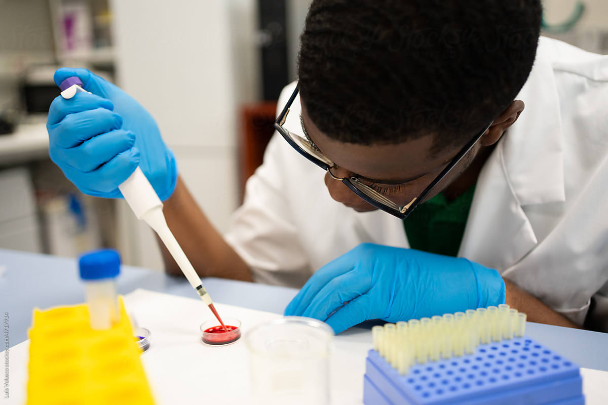 Black Man Scientist Focused Using The Pipette In The Lab.