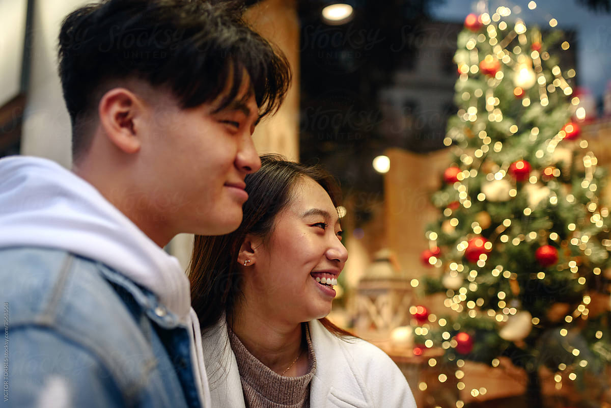 Chinese young couple hanging out on the street by night in Christmas time
