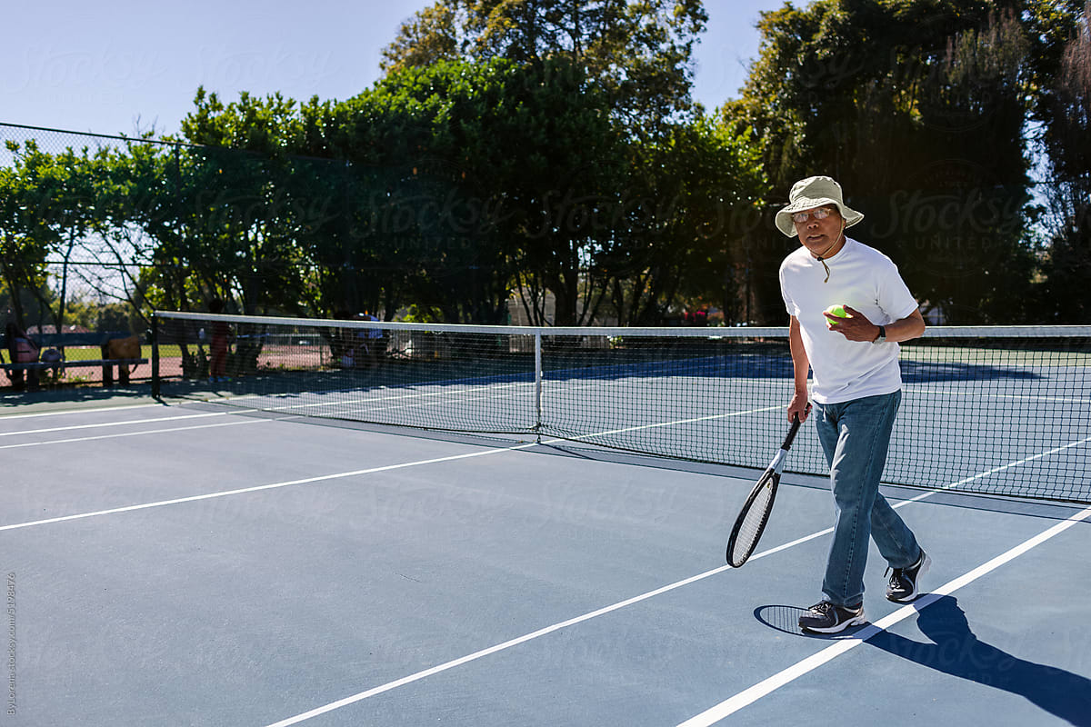 Mature man playing tennis outdoor in summer