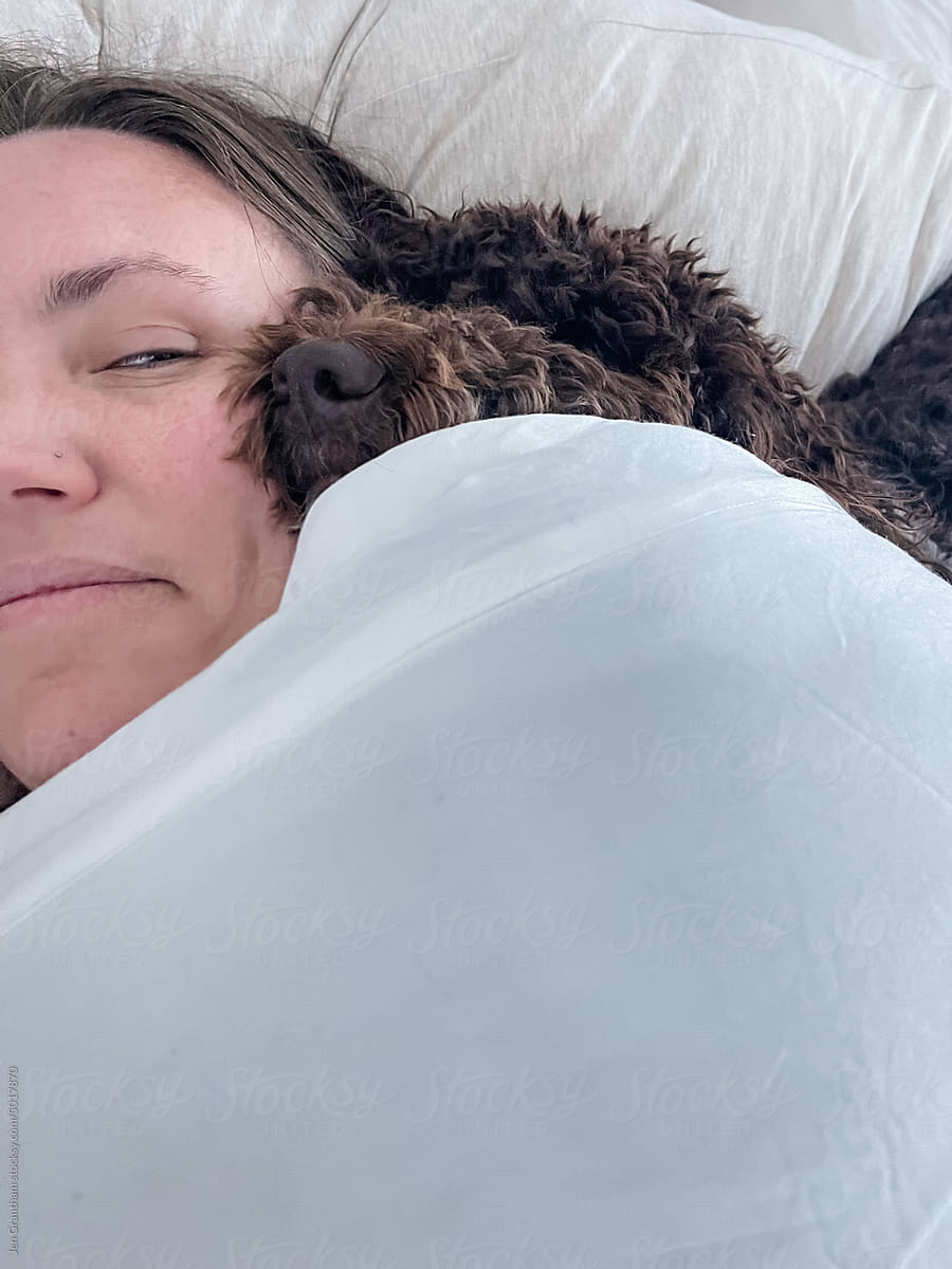Woman looking at dog sleeping on her head