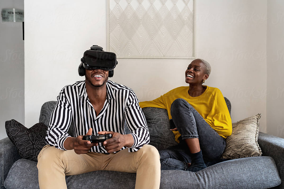 Black gamer exploring virtual reality near girlfriend
