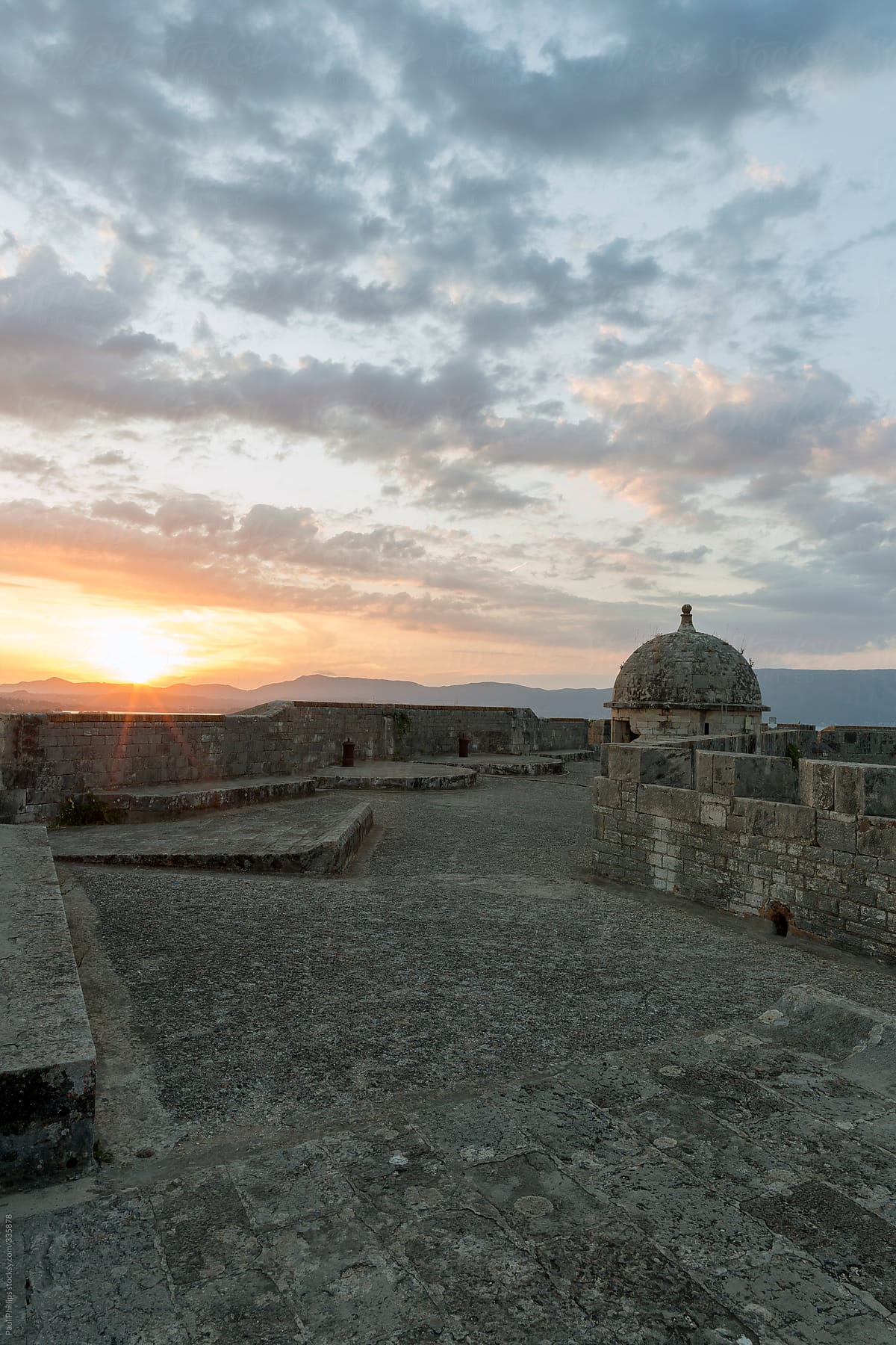 Sun setting over the battlements of an old fort