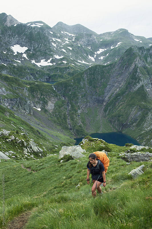 Young woman backpacker hiking in the Pyrenees mountains