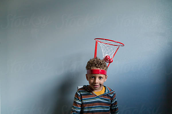 Boy Reads On Couch In Front Of Rainbow Streamers by Stocksy Contributor  Jennifer Bogle - Stocksy