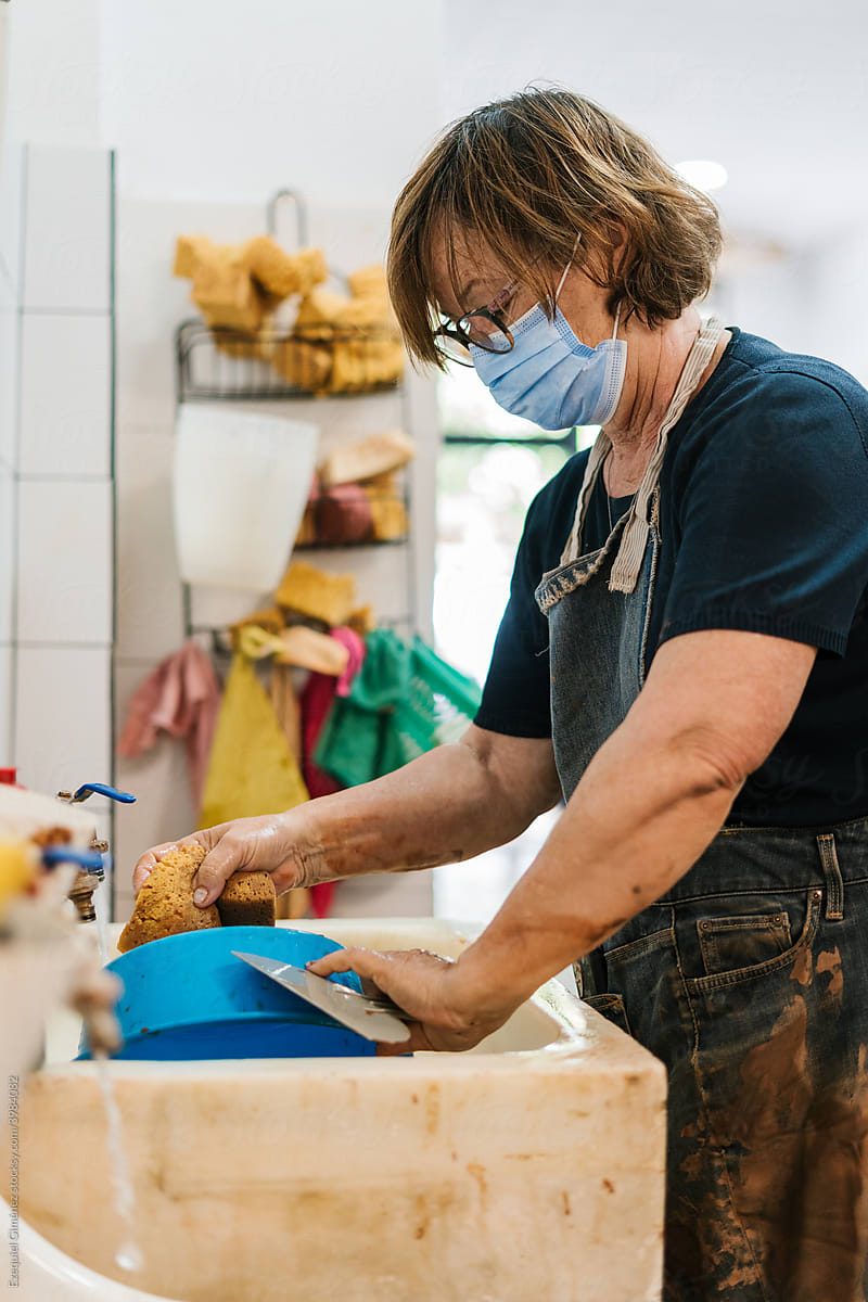 Adult woman washing a professional pottery vessel