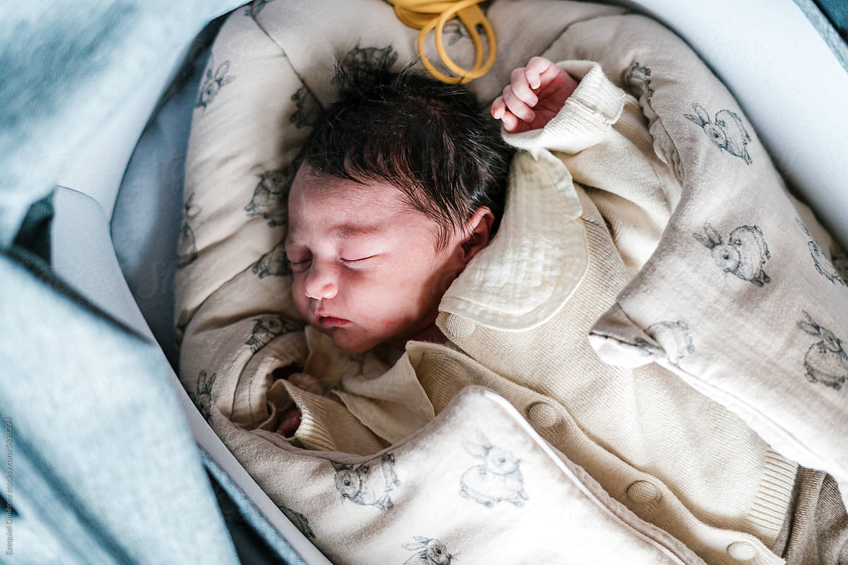 Sleeping newborn child in warm clothes in baby nest
