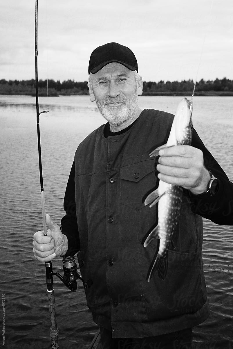Film photo portrait of a fisherman with a fish