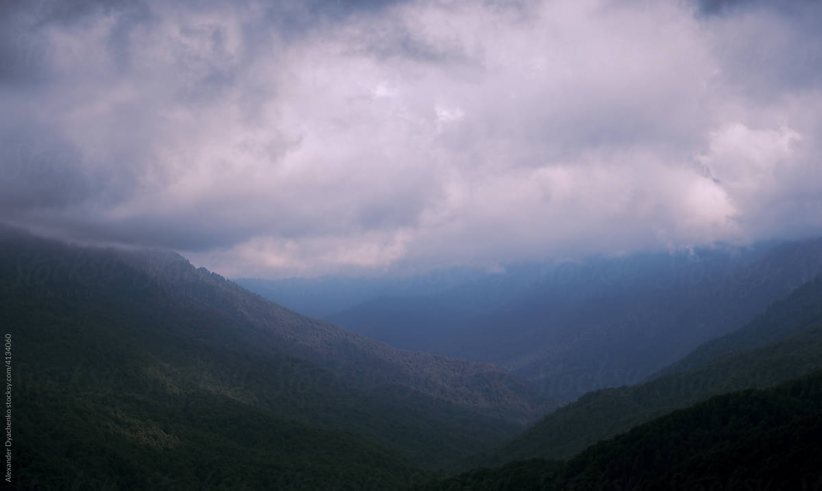 Green mountains valley with heavy sky