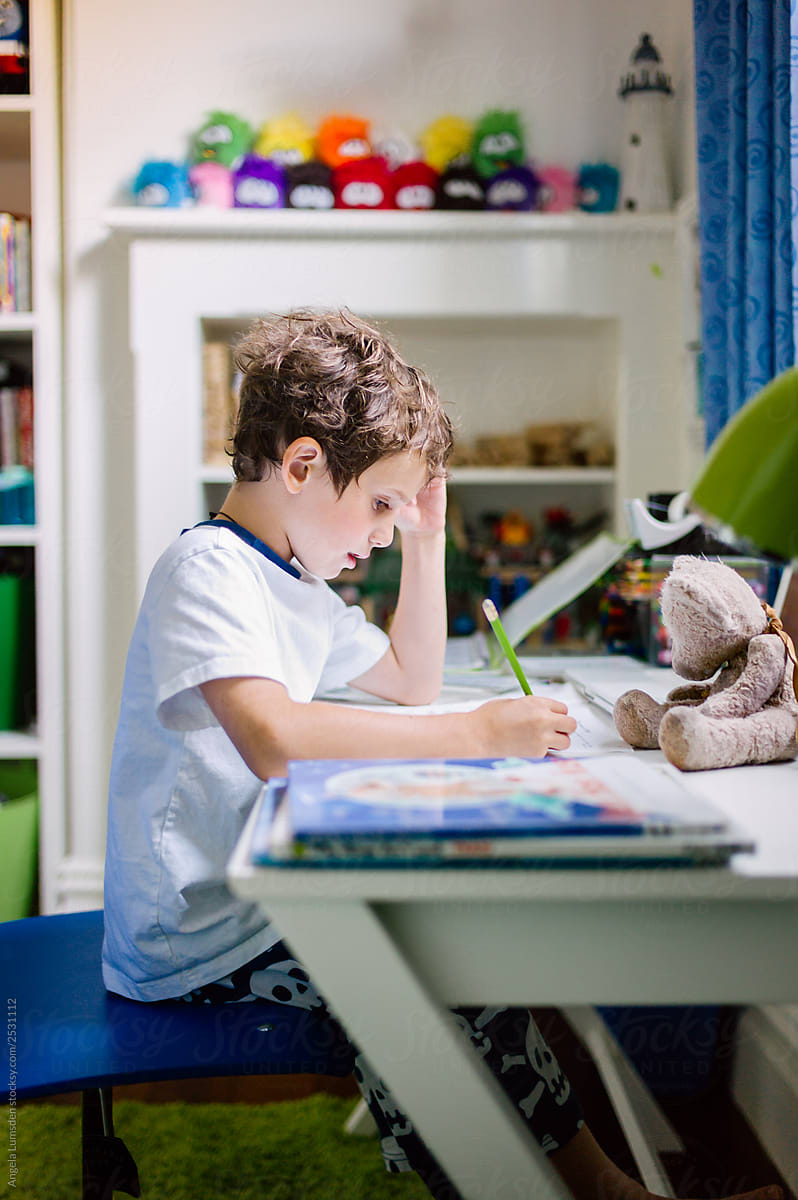 Small Boy Doing Homework At Desk In His Bedroom By Angela Lumsden