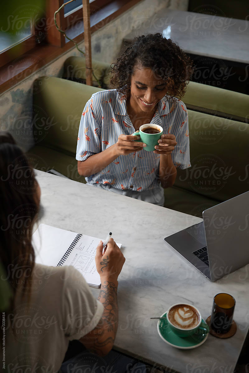 Two female entrepreneurs on a meeting in cafe