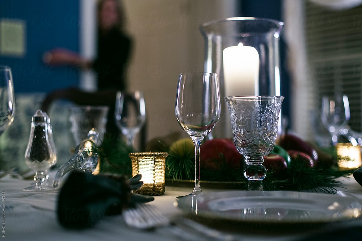 A woman turns the lights down on a formal table set for Thanksgi