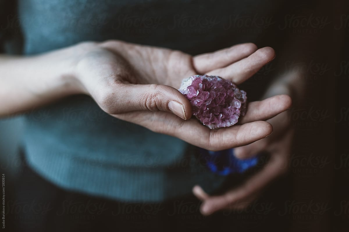 Woman holding pink crystal in her hands