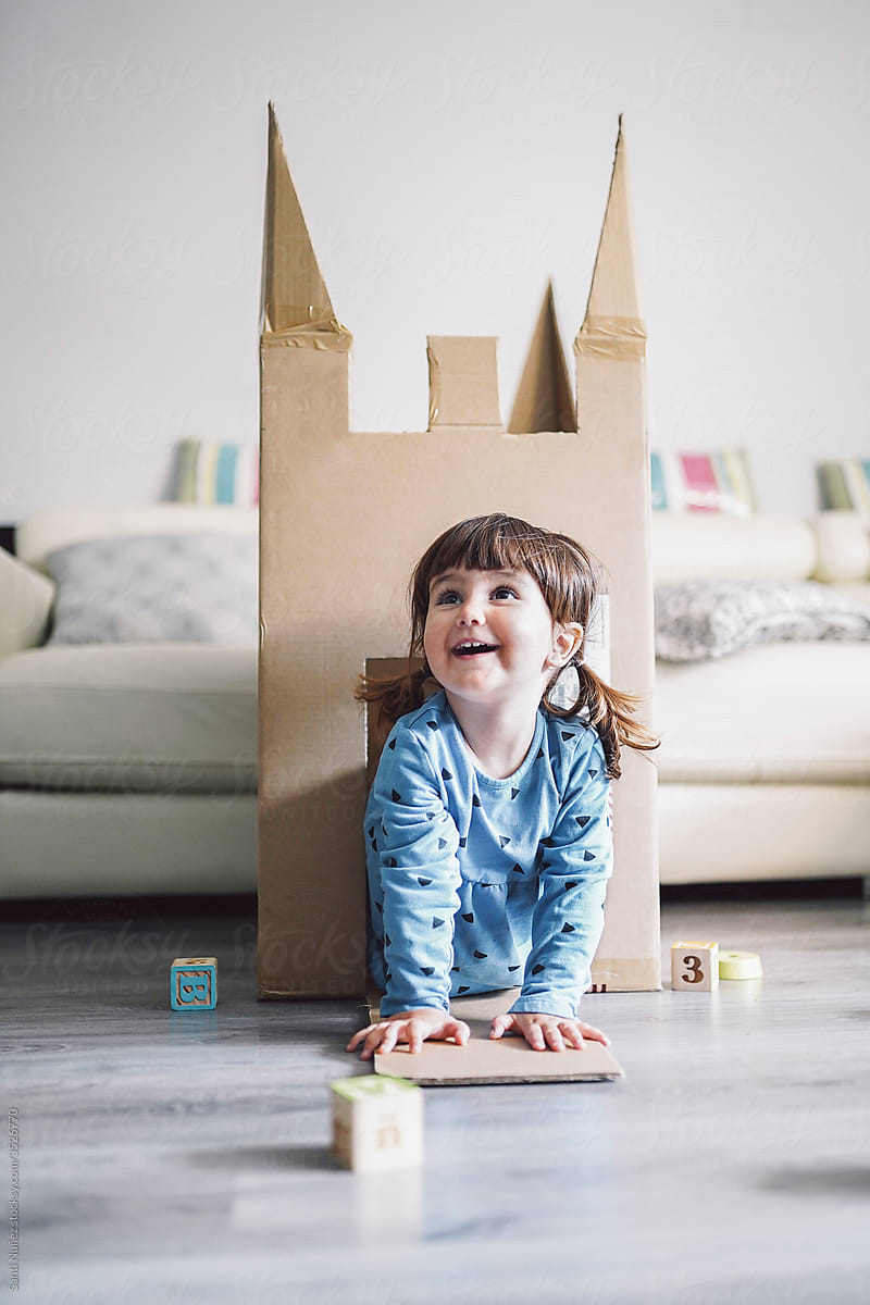 Girl playing with a paper castle