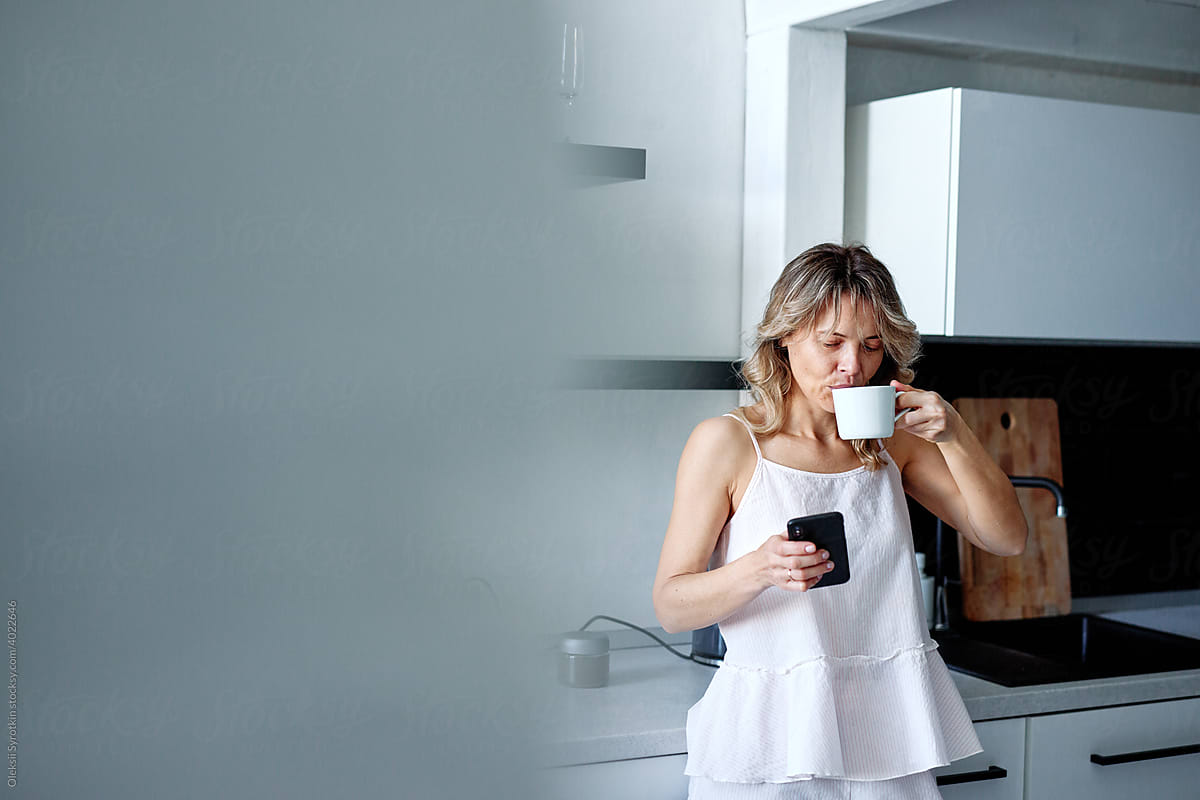 Female having coffee and using phone