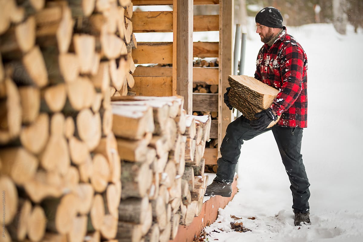 Man With Beard Stacking Wood At Cottage Winter Wood Pile