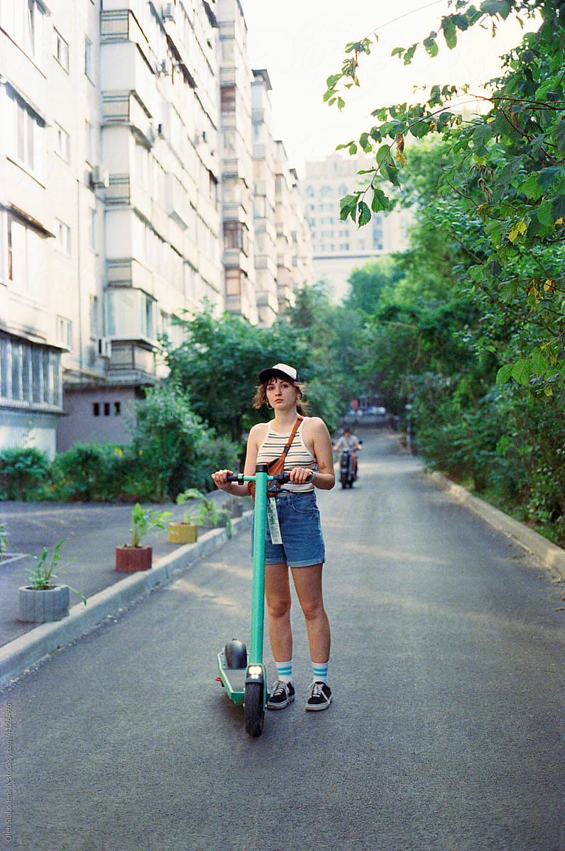 Woman with scooter near the building