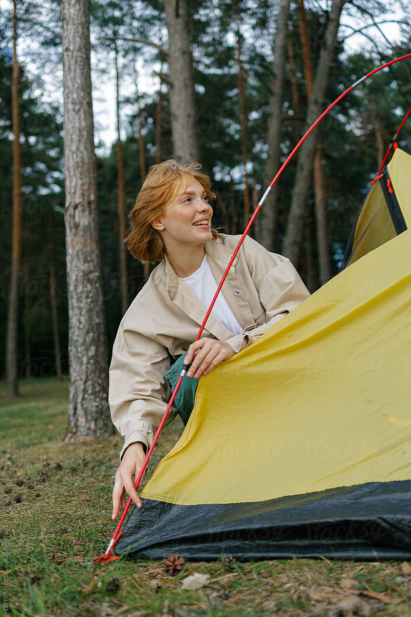 A woman sets up a tent
