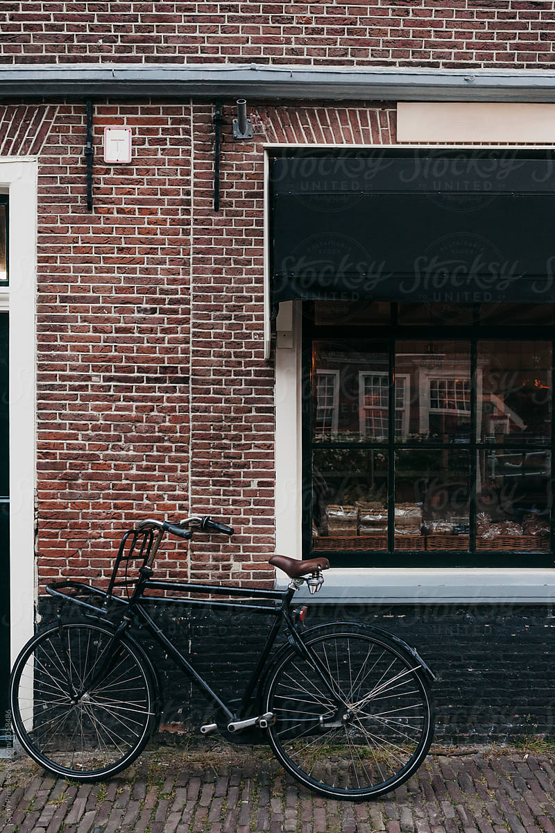 A bicycle parked against a brick building