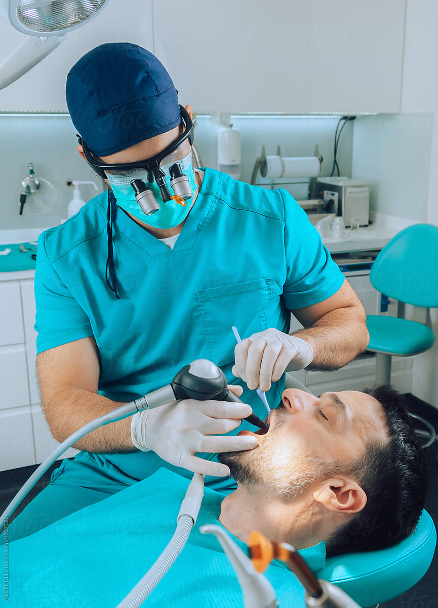 Dental Surgeon checking patient teeth with instruments
