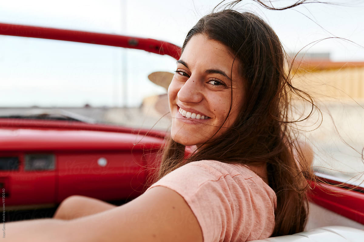 Smiling woman riding in a convertible