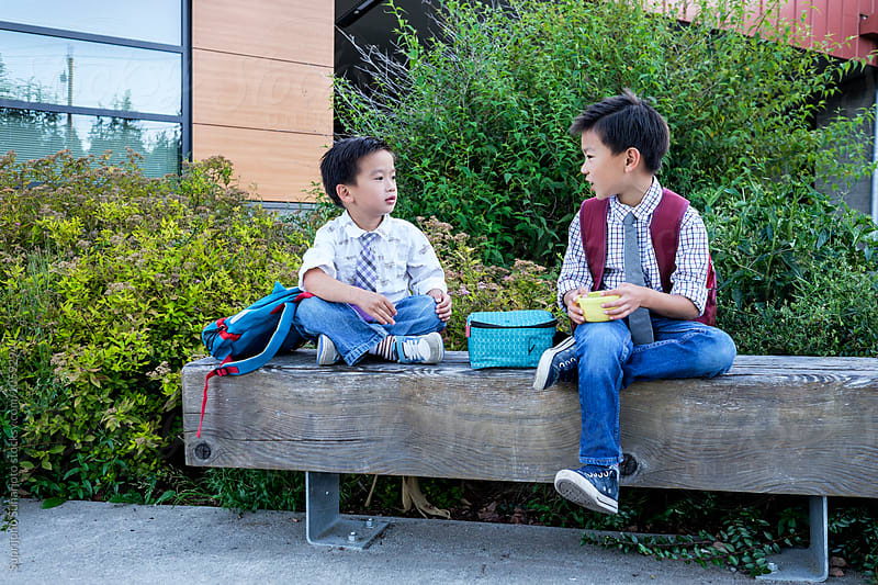 Back to school: Asian kids eating snack together in school