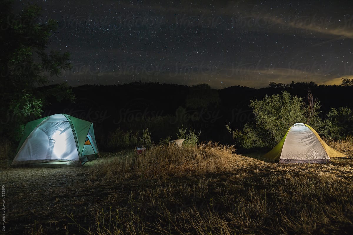 Camping in tents at night under bright sky