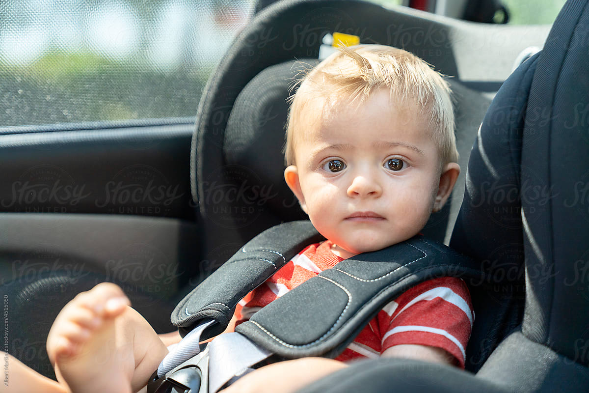 Cute toddler in car seat looking at the camera