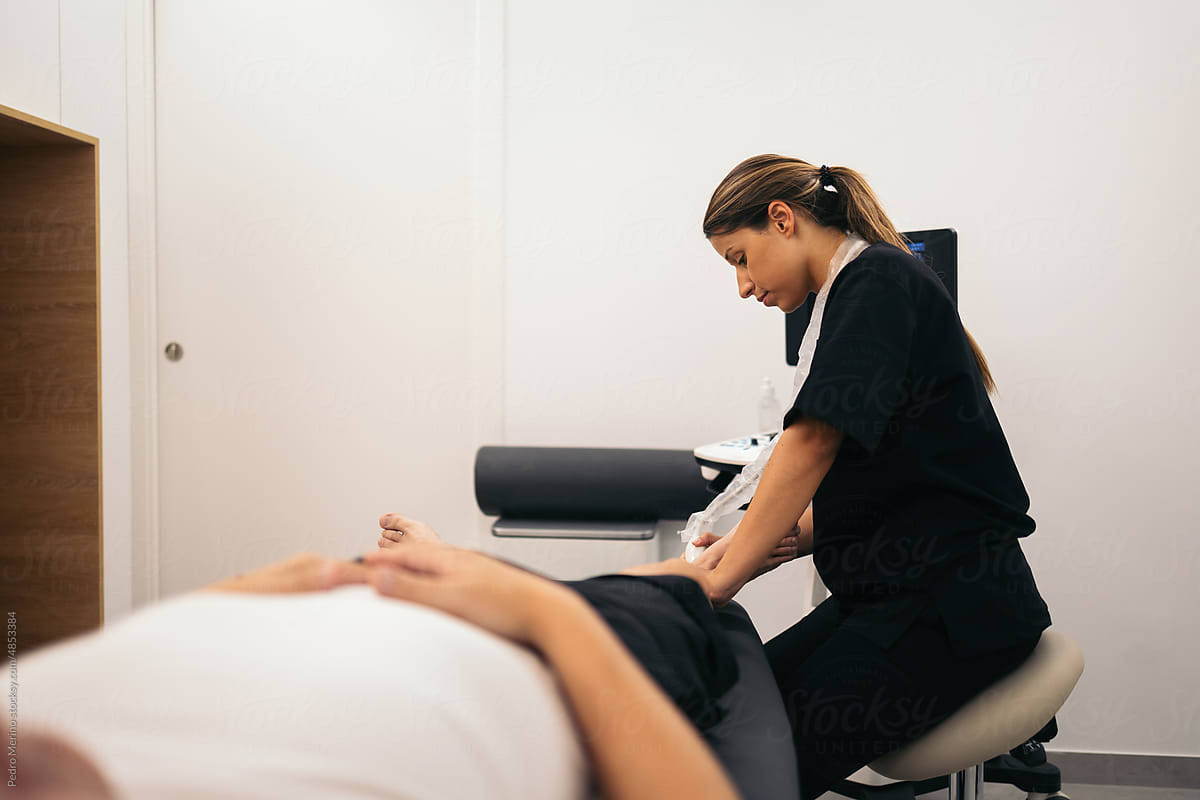 Professional physiotherapist doing an ultrasound scan to a patient