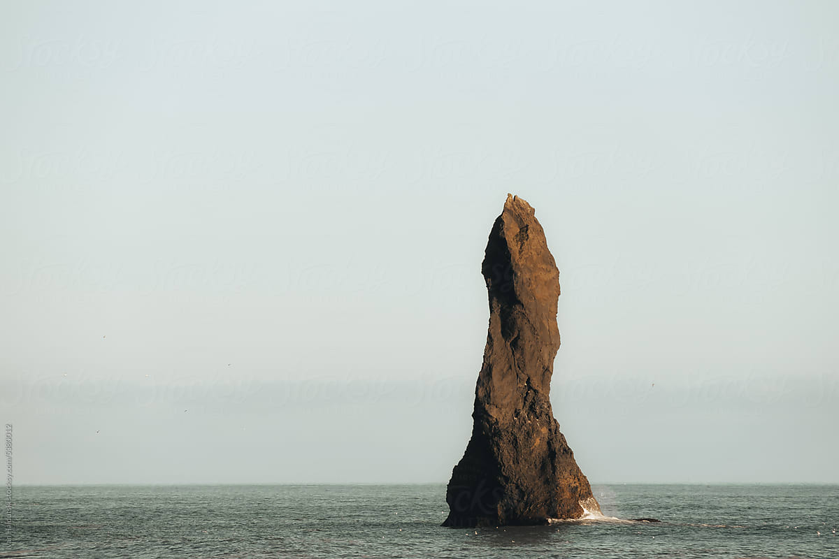 A rock formation known as Troll Finger rising out of the ocean waters