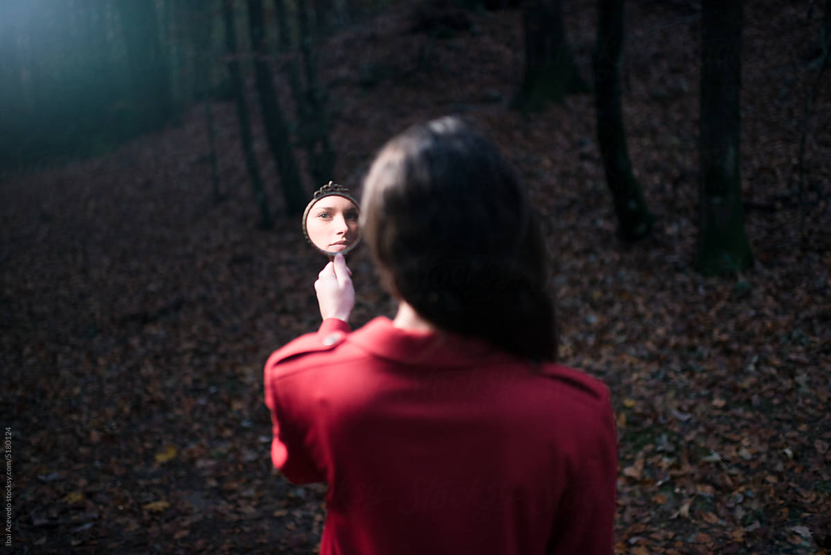 Portrait of woman face reflected in mirror at forest
