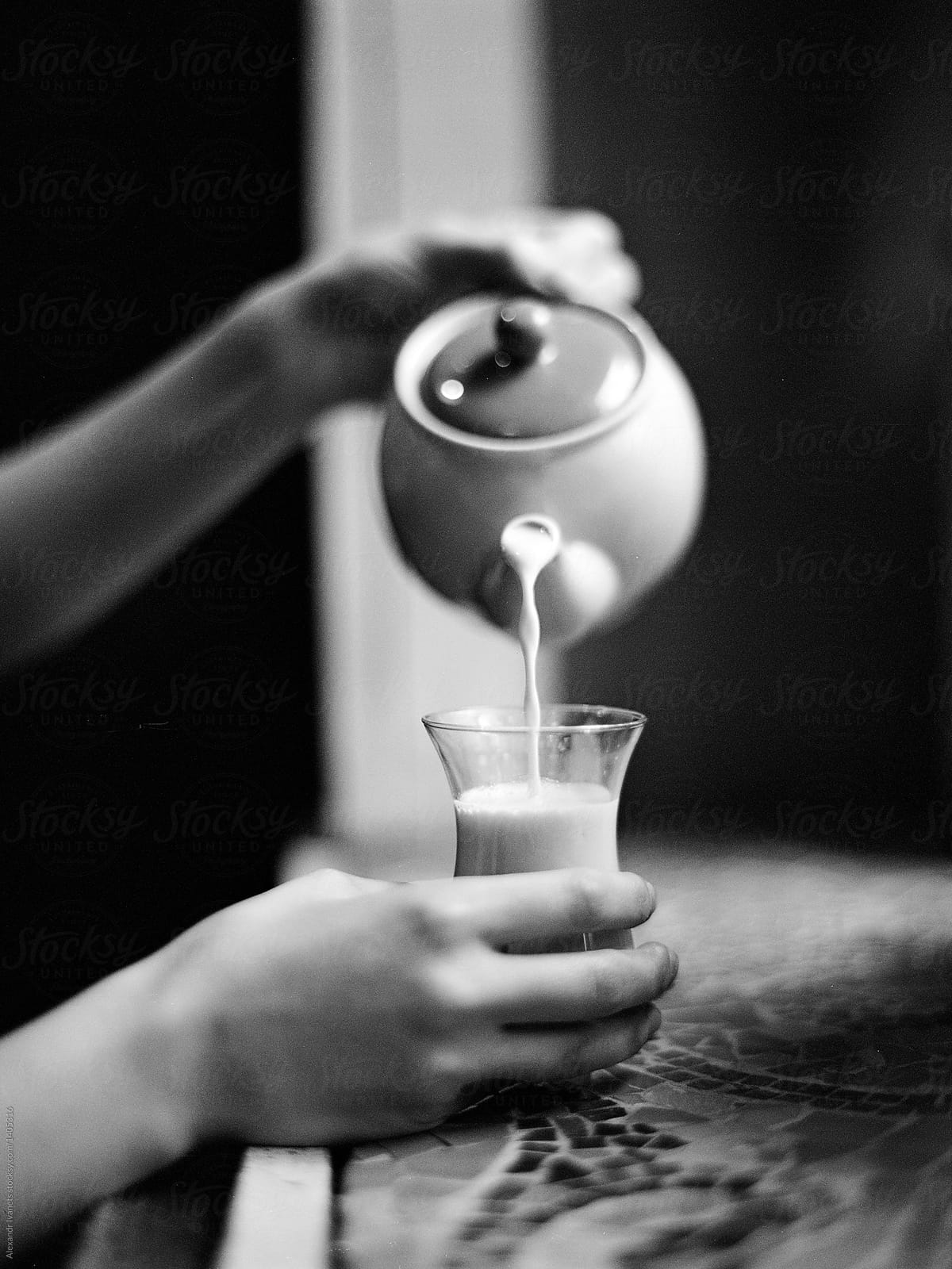 Crop woman pouring milk in glass