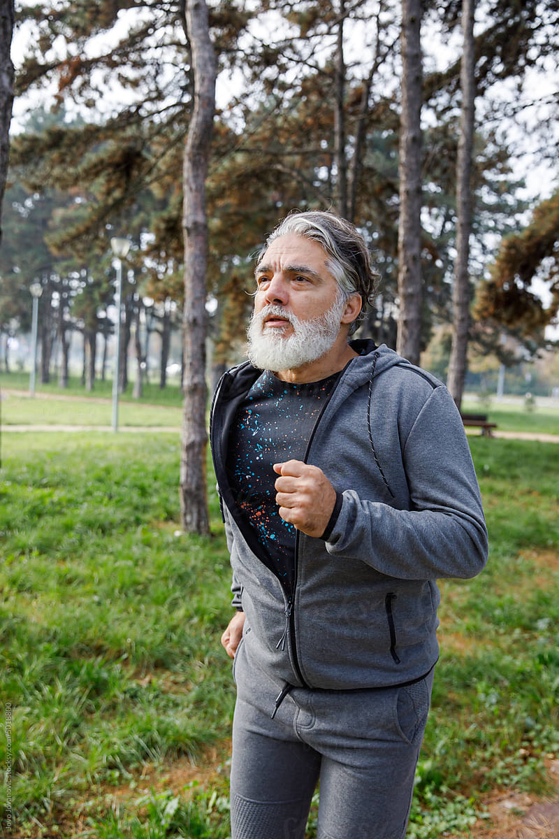 Gray hair man jogging while exercising in park