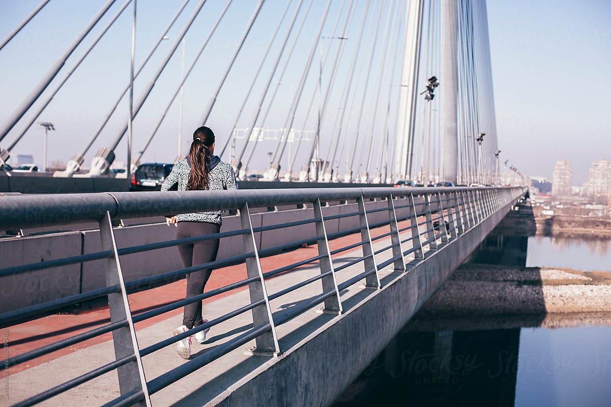 Woman Running On The Bridge Del Colaborador De Stocksy Lumina Stocksy