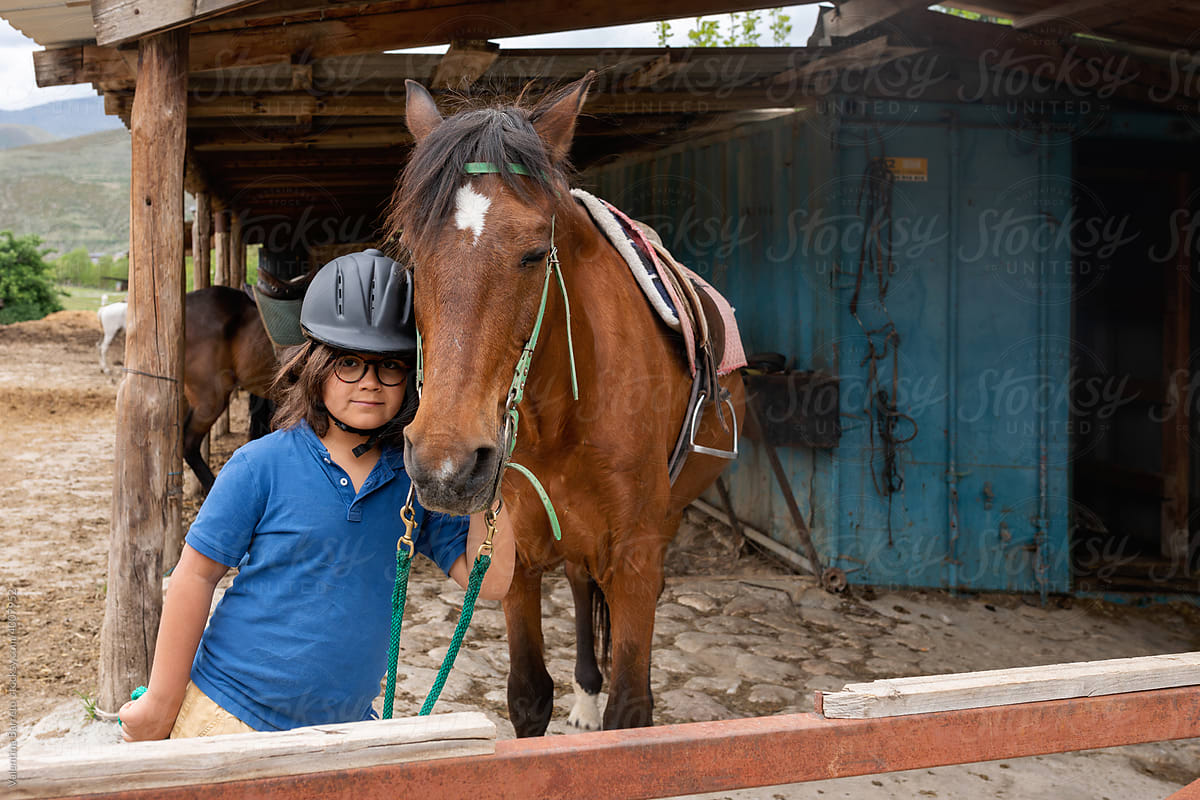 Charming kid with an horse at stable