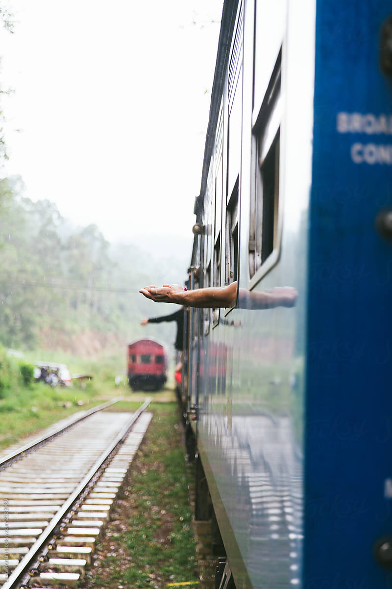 Train Passenger Catching Rain With Arms Outstretched