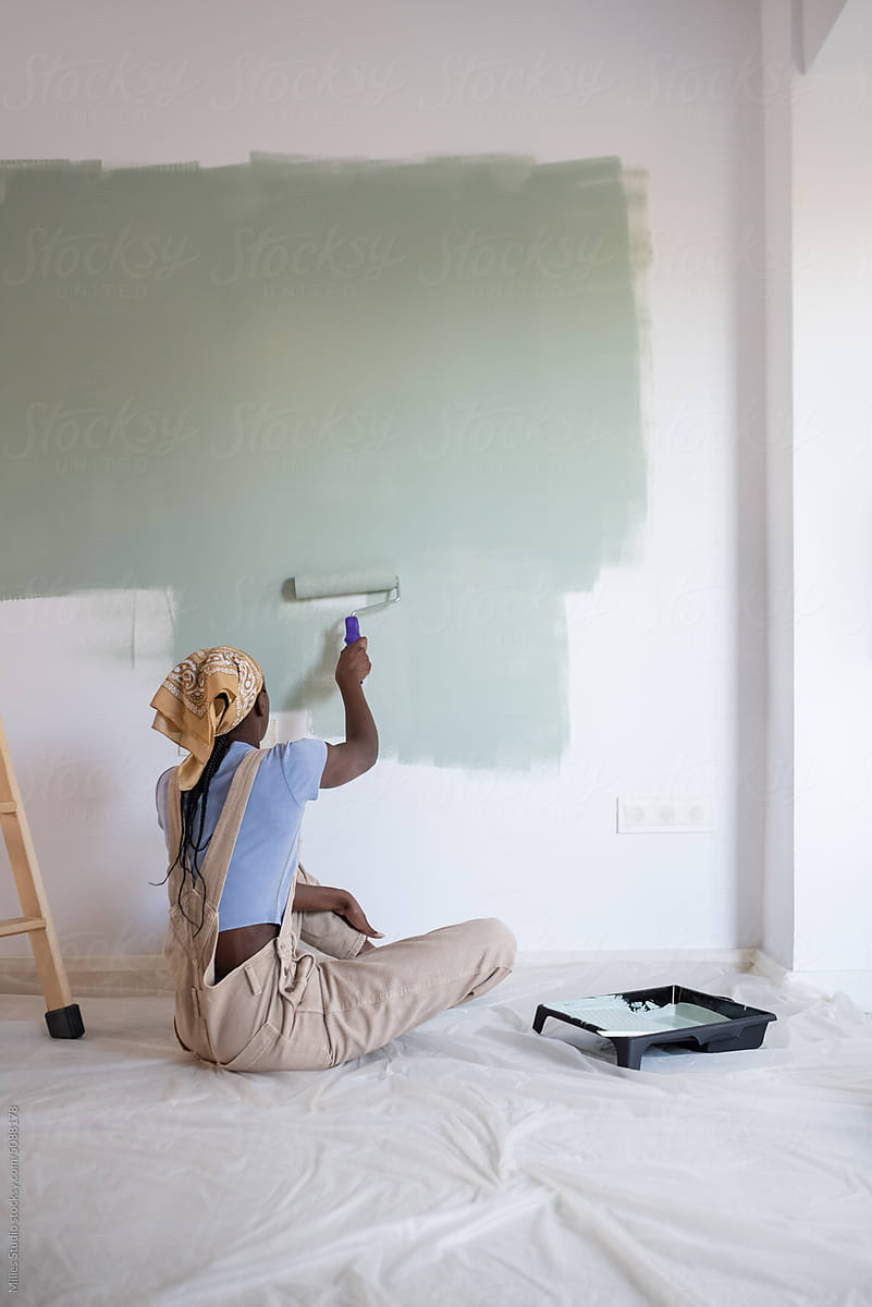 Unrecognizable black woman changing wall color
